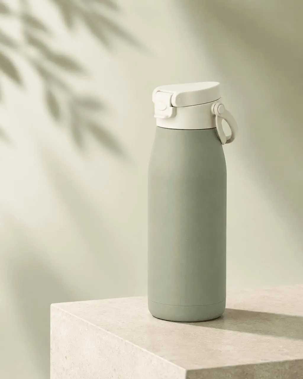 Shopify hero image of a sage-green bottle on a warm stone pedestal